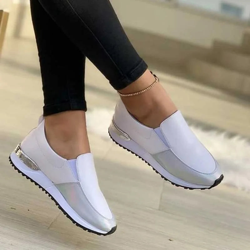 Tênis feminino slip-on de fibra sintética com detalhe metalizado e solado antiderrapante.