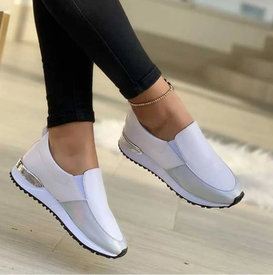 Tênis feminino slip-on de fibra sintética com detalhe metalizado e solado antiderrapante.